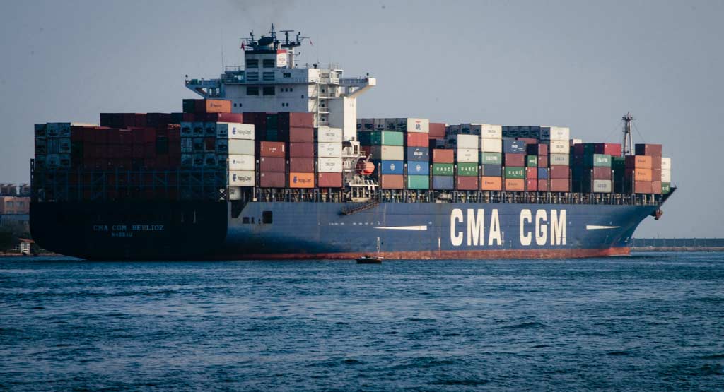A cargo ship carrying countless containers on sea during daytime